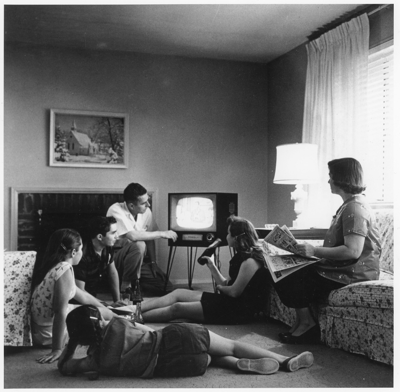 A 1950s family gathered on the floor watching television